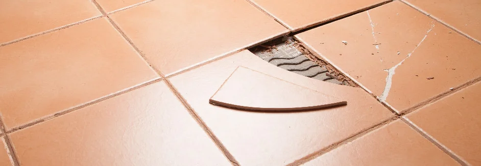 Kaputte Fliese auf Fliesenboden